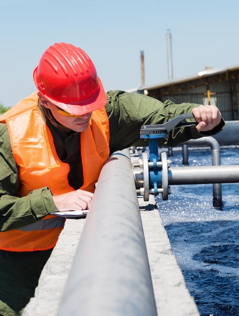An engineer controlling a quality of water ,aerated activated sludge tank at a waste water treatment plant